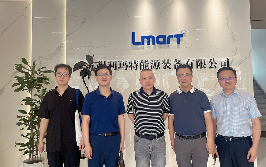 双方代表在公司形象墙前合影